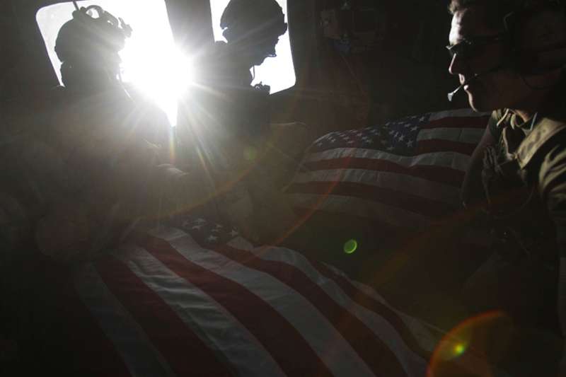 Kandahar Province, Afghanistan: Air Force pararescuemen ride in the back of a medevac helicopter with the bodies of two U.S. soldiers killed in a roadside bomb attack in Kandahar Province, October 10, 2010. Photographer Guttenfelder describes the scene:  When the pararescue guys were covering the bodies, they only had two flags with them. The wind was shipping through the open window...and the wind caught it and it blew out the window and they lost it. So they only had one flag. (But) one of the pilots had a flag that he kept behind the plate of his flak jacket, one that he'd kept with him for every deployment he'd ever done: Iraq, Afghanistan. He flew over Washington DC with it, his children had kissed it. He took it out and passed it to the back of the helicopter and that was one of the flags they used to cover one of the guys. The family of the soldier who died, who was covered by the donated flag, has reached out to me to ask for a contact for the pilot. They are hoping to give the flag back to him.