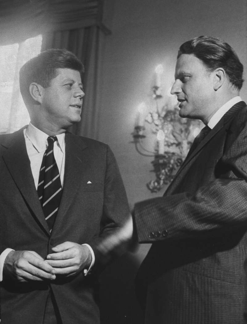 The Rev. Billy Graham speaks with President John F. Kennedy at a prayer breakfast in February 1961. Graham has had an audience with every sitting president from Harry Truman on.