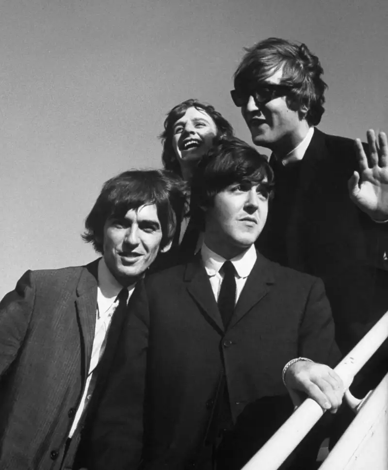 The Beatles wave to fans as they arrive at the Los Angeles airport in August 1964 for a press conference at the start of their second American tour.