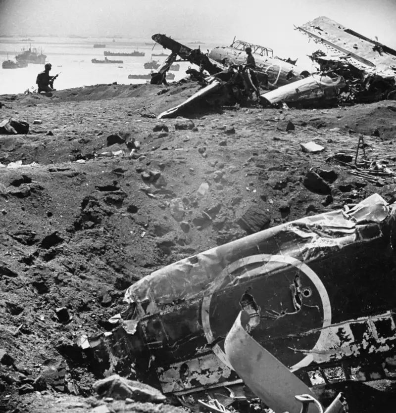 Warplanes Litter the Beach at Iwo Jima
As American ships invade Iwo Jima in Februay 1945, Japanese airplanes lie wrecked on the beach, but ground troops will defend the island fiercely for 35 days.