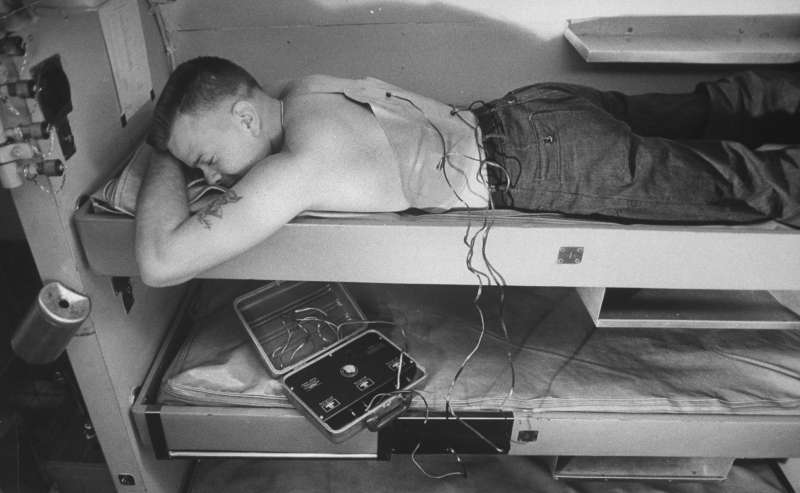A crew member aboard the submarine  uses an electronic device to massage his muscles and maintain fitness during a voyage.