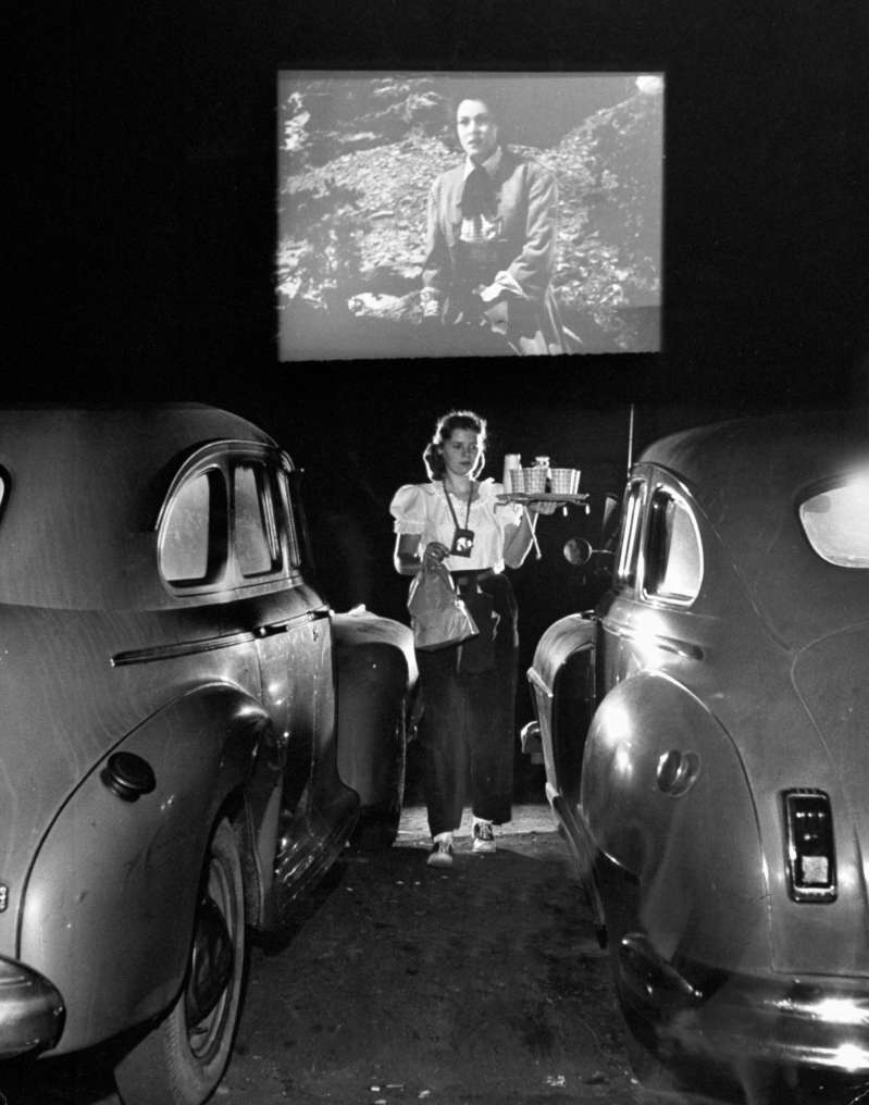 A carhop tends to patrons at a drive-in movie theater in 1948. With a more mobile society came car-oriented services, like theaters where you stayed in your car and waiters who came to your car door.