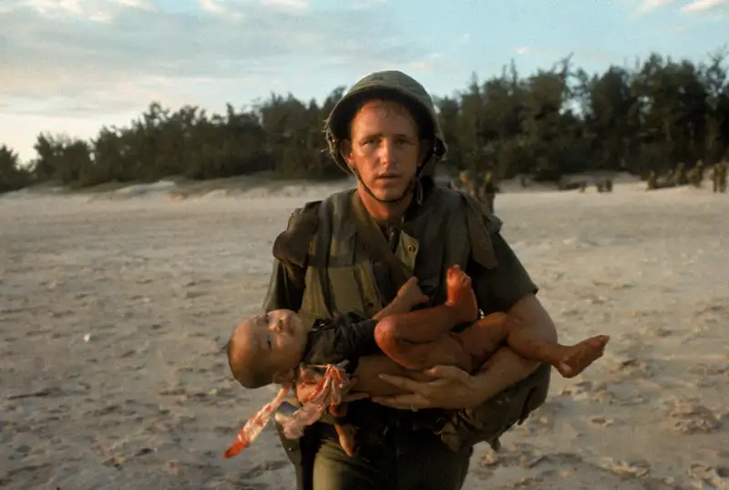 Paul Schutzer's jarring photograph of a U.S. medical corpsman running with an injured Vietnamese baby after the child's mother wandered into a combat zone has a nightmarish feeling about it -- a feeling only heightened when one notices that the wounded child's eyes are locked on the viewer, as if asking for help, or quietly passing judgment.