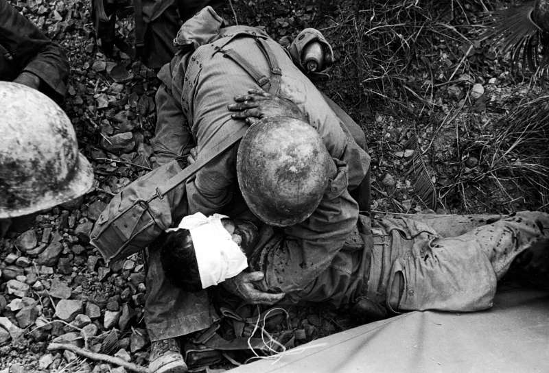 Brothers in Arms
              
              An American soldier comforts a badly wounded comrade during the fight to take Saiapn from the occupying Japanese troops.