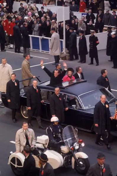 On January 20, 1969, surrounded by Secret Service men, Richard M. Nixon waves from his limo on the way to his Inauguration. After the assassination of John F. Kennedy, presidential security was beefed up.