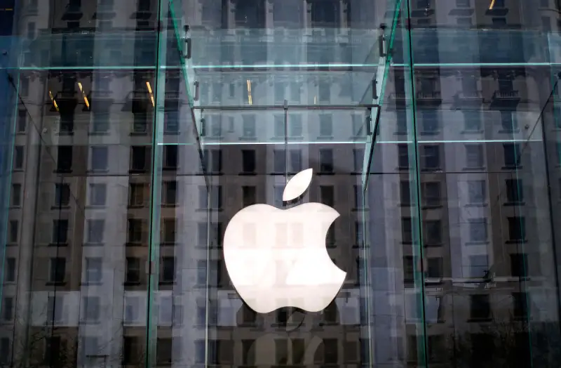 The Apple logo hangs inside the glass entrance to the Apple Store on 5th Avenue in New York City.