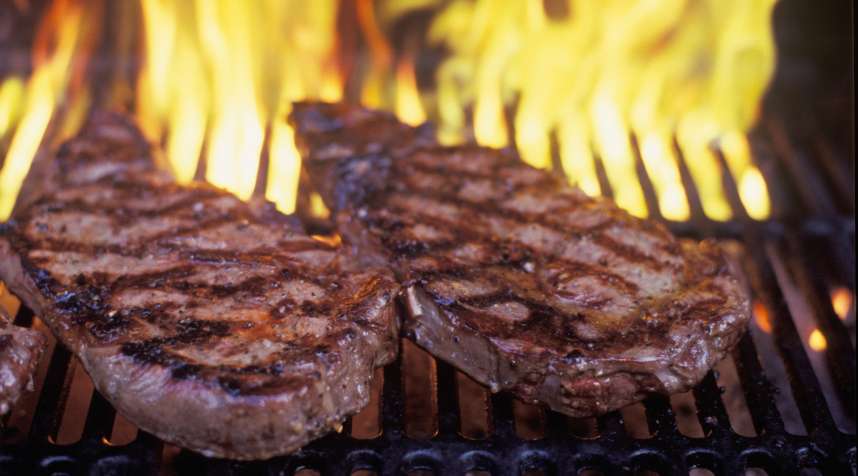 Flamed grilled steaks on a barbecue