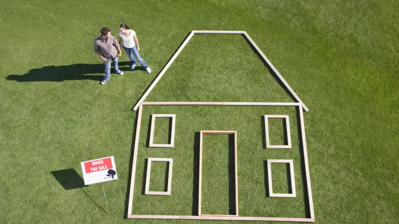 couple standing by outline of house