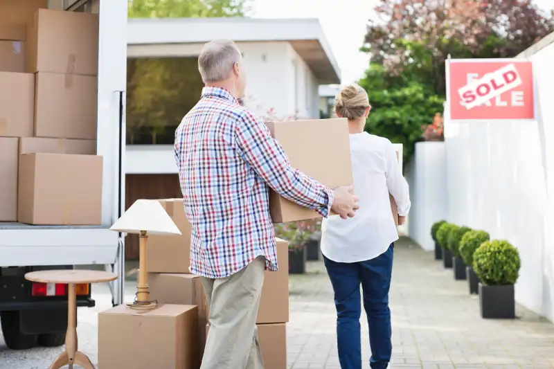 Older unmarried adults unloading packing boxes