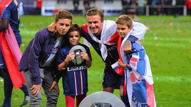 David Beckham posing with the Ligue 1 trophy and his sons