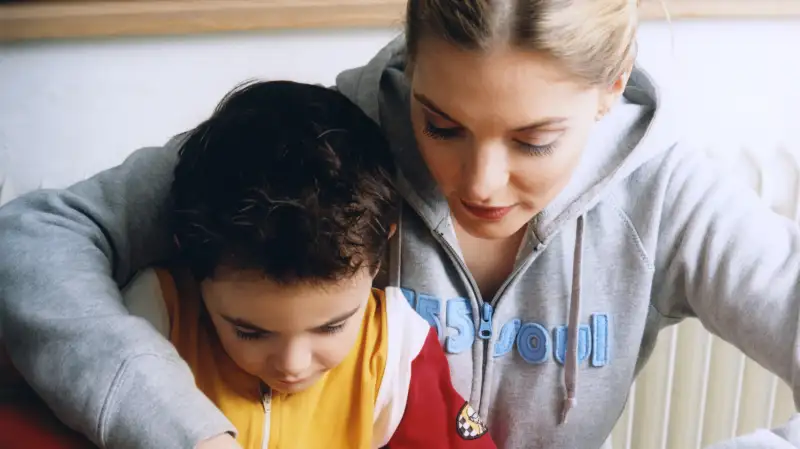 College student teaching child to cook.