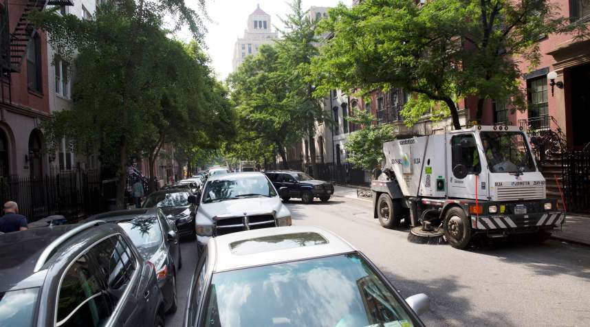 Double-parked cars on an alternate-side parking day, which takes place for street cleaning, in New York, June 16, 2014. A proposal to allow drivers to return to parking spaces once street sweepers pass has set off a fevered debate.