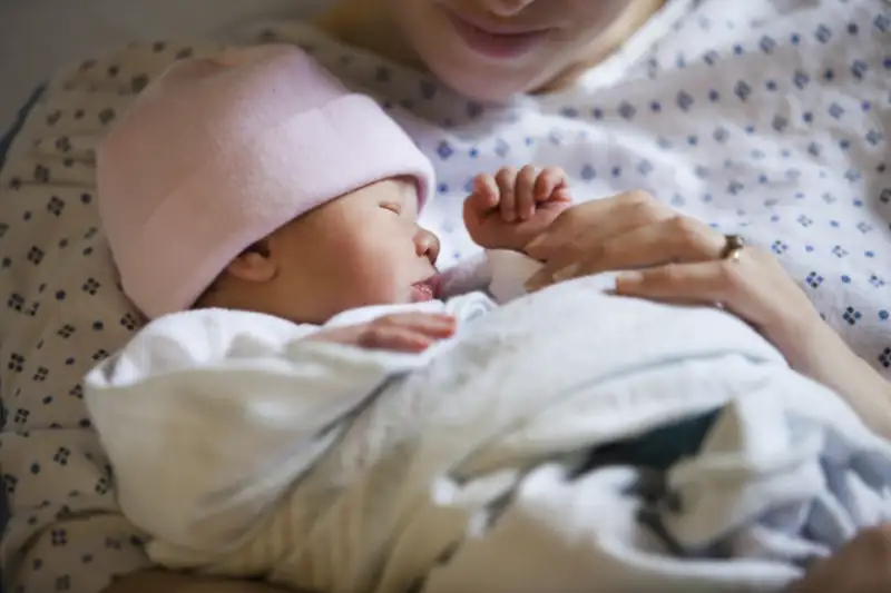 Portrait of newborn girl (0-1months) with mother