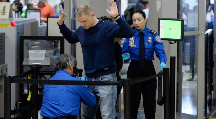 An airline passenger is patted down by a Transportation Security Administration (TSA) agent at Los Angeles International Airport.