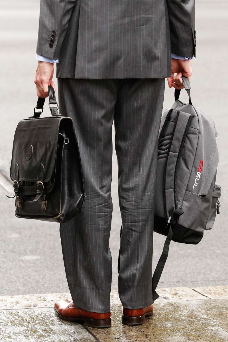 Businessman carrying backpack and briefcase