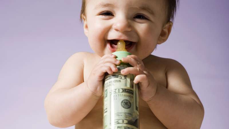 Baby drinking milk bottle filled with cash