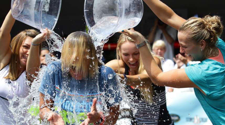 Tournament Director Anne Worcester takes the ALS Ice Bucket Challenge with the help of Tennis players Simona Halep, (left), Caroline Wozniack, (centre), and Petra Kvitova, (right), during the Connecticut Open at the Connecticut Tennis Center at Yale, New Haven, Connecticut, August 17, 2014.