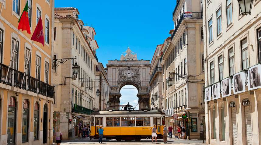 A street car pauses in front of Lisbon's Triumphal Arch.