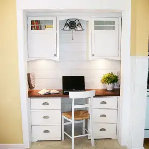 After: Opening up the closet helped give the family access to more precious floor space. Planked walls and a desk finished with bin pulls fit with the home's Craftsman cottage look. Six drawers and two upper cabinets offer plenty of room for stashing school supplies and paperwork.