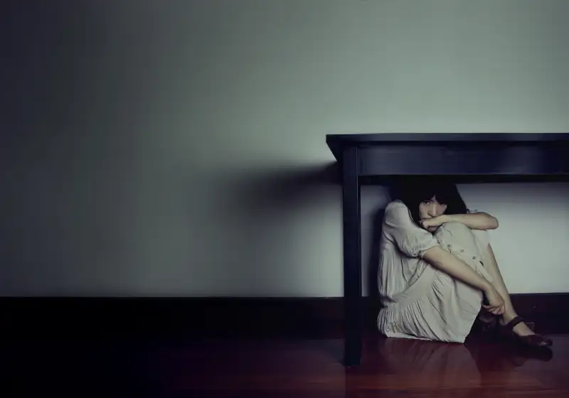 Girl hiding under table
