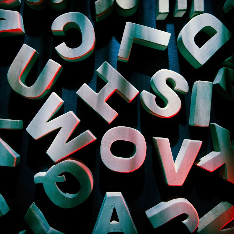 Jumble of wood letters on background