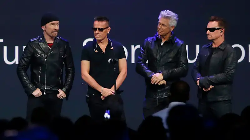 Apple CEO Tim Cook (L) stands with Irish rock band U2