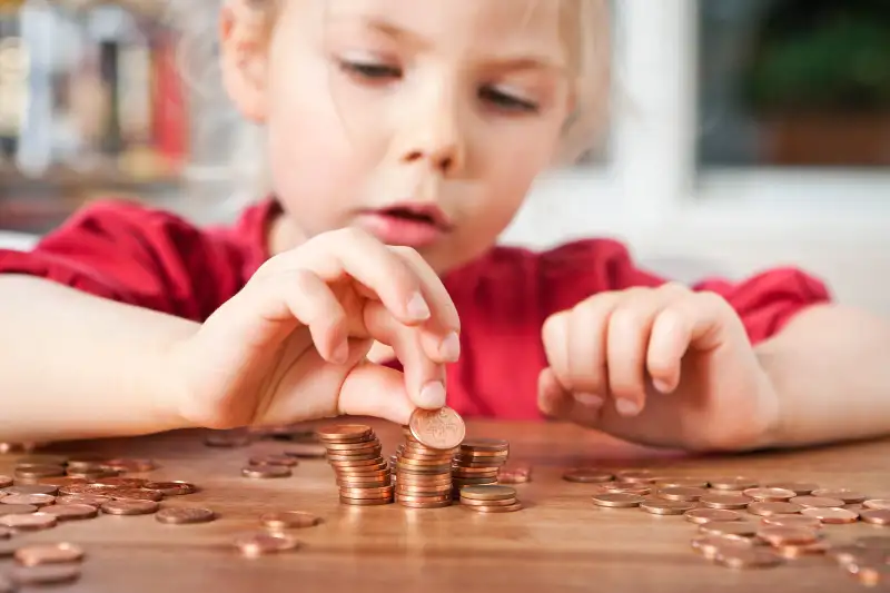 toddler counting pennies on table