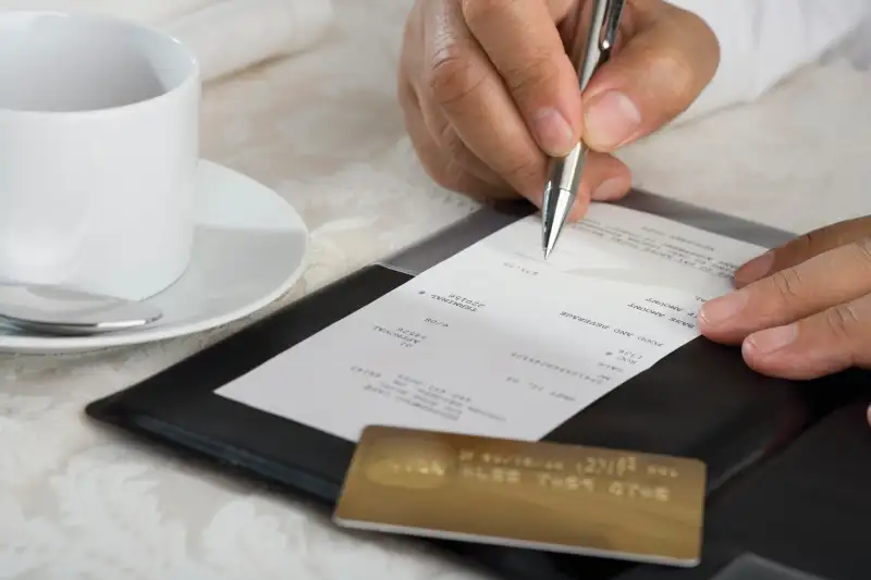 Man signing credit card bill at restaurant