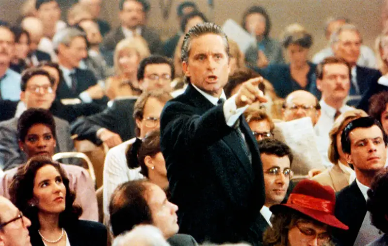 WALL STREET, Michael Douglas (standing), Saul Rubinek (head, right) 1987.