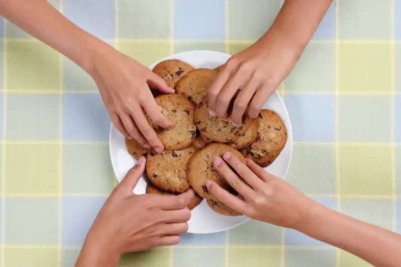 Kids taking cookies from plate