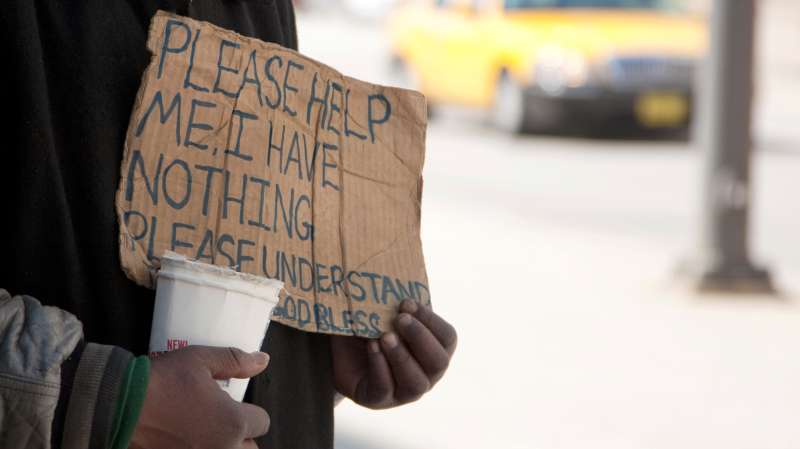 panhandler holding up sign