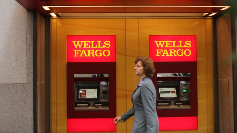 A woman walks past teller machines at a Wells Fargo bank in San Francisco, California.