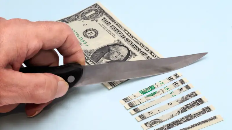 knife cutting dollar bill