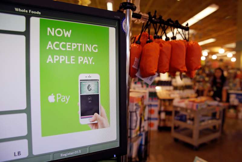 a cash register terminal promotes usage of the new Apple Pay mobile payment system at a Whole Foods store in Cupertino, Calif.