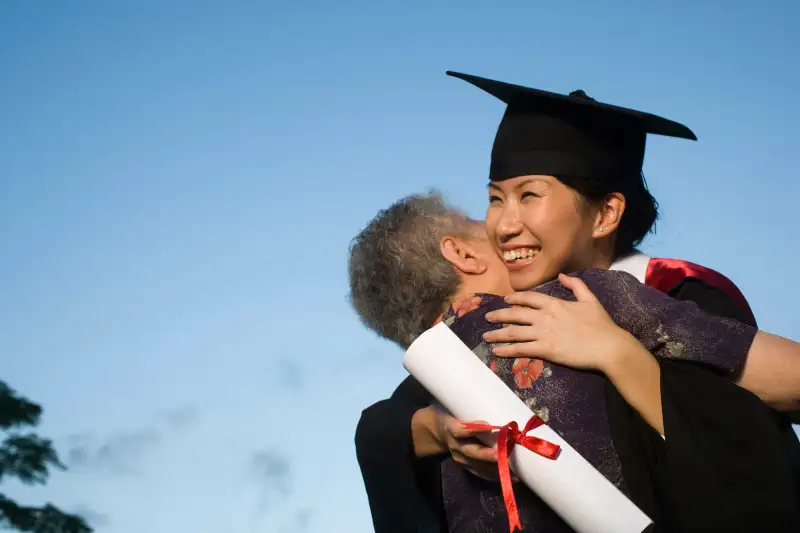 granddaughter hugging grandma after graduating from college