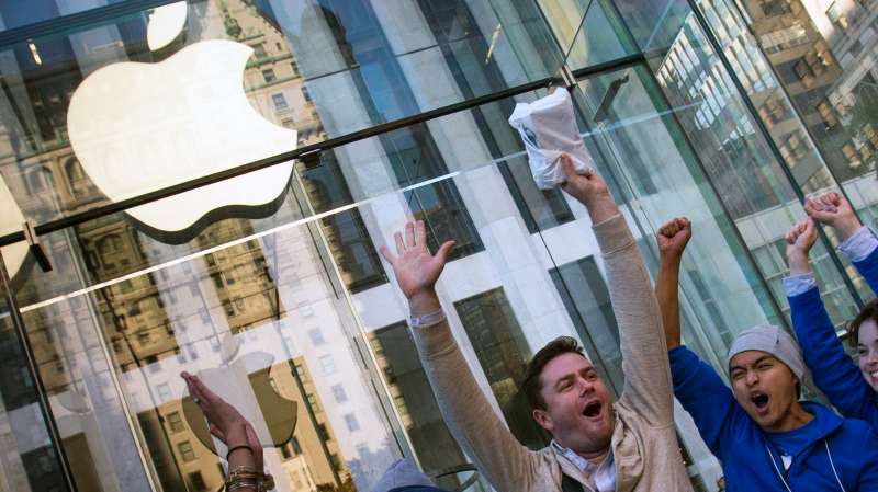 Local resident Andreas Gibson celebrates after being the first to exit the Fifth Avenue store after purchasing an iPhone 6 on the first day of sales in Manhattan, New York September 19, 2014.