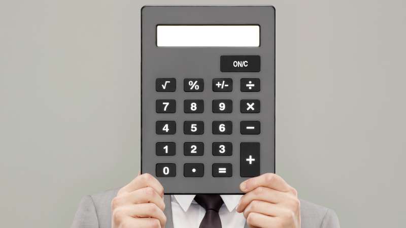 man holding calculator in front of his head