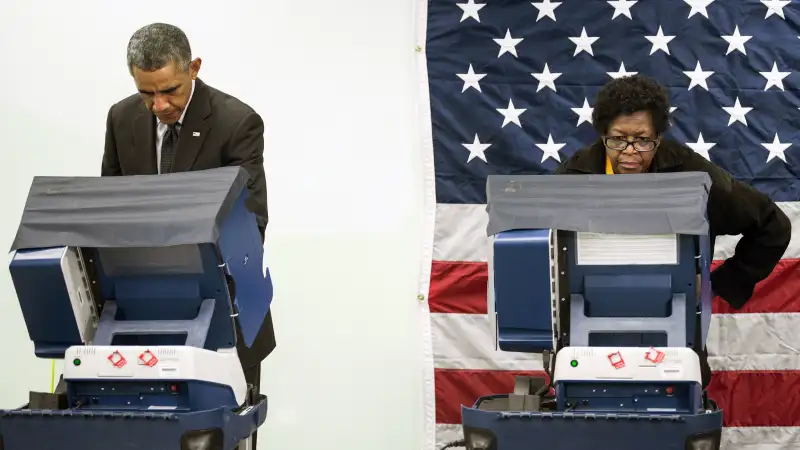 President Barack Obama(L) casts a ballot in early voting for the 2014 midterm elections at the Dr. Martin Luther King Community Service Center October 20, 2014 in Chicago, Illinois. The President took a break from campaigning for Democratic Governor Pat Quinn to cast his vote.