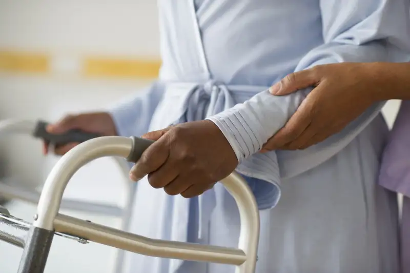 woman helping woman with walker