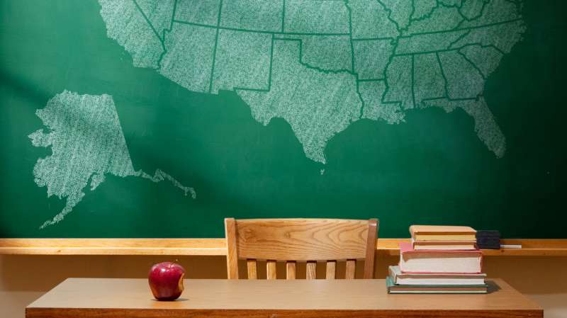 Classroom with map of United States on chalkboard. Wyoming is shaded pink.