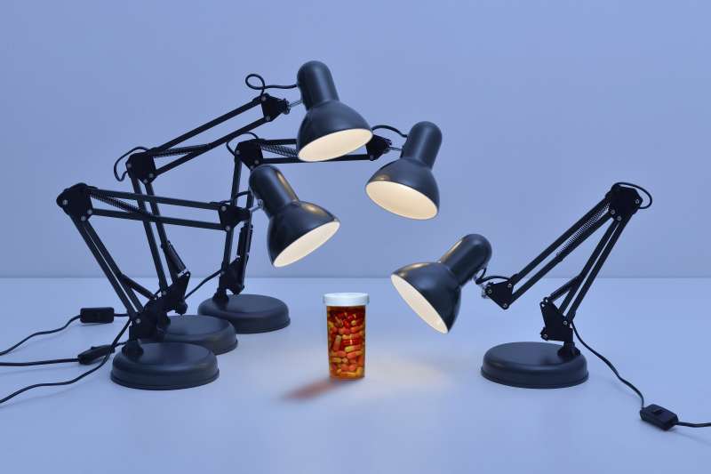 Office lamps pointed at pill bottle interrogation-style