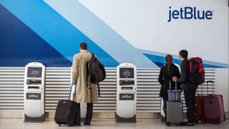 Customers check in at JetBlue's counter at John F. Kennedy Airport in the Queens borough of New York City.