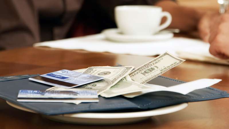 restaurant bill with credit cards and cash