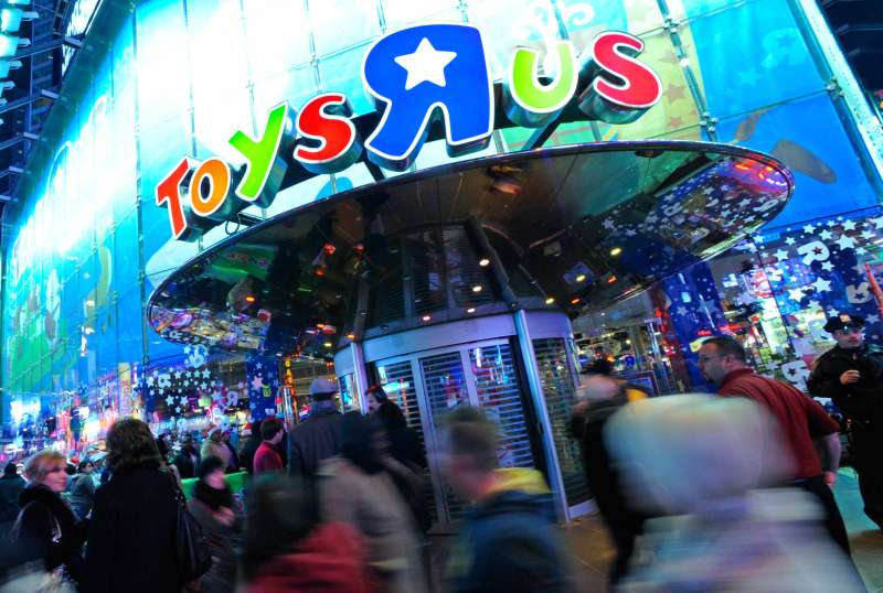 Pedestrians walk by a Toy  R  Us Inc. store during a Black Friday sale in New York, in 2011.