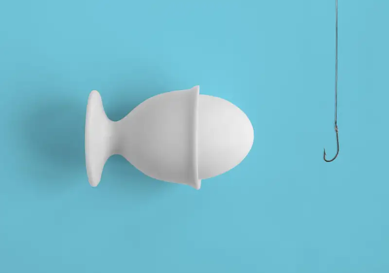 Egg in cup tilted to look like fish swimming toward hook