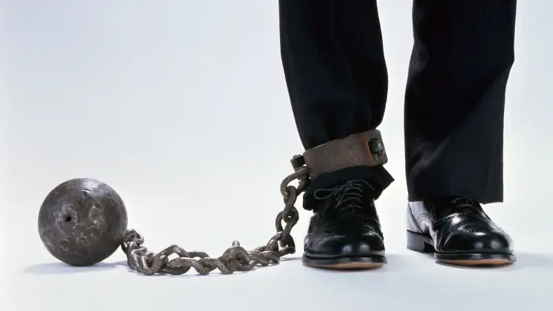 man with ball & chain attached to leg