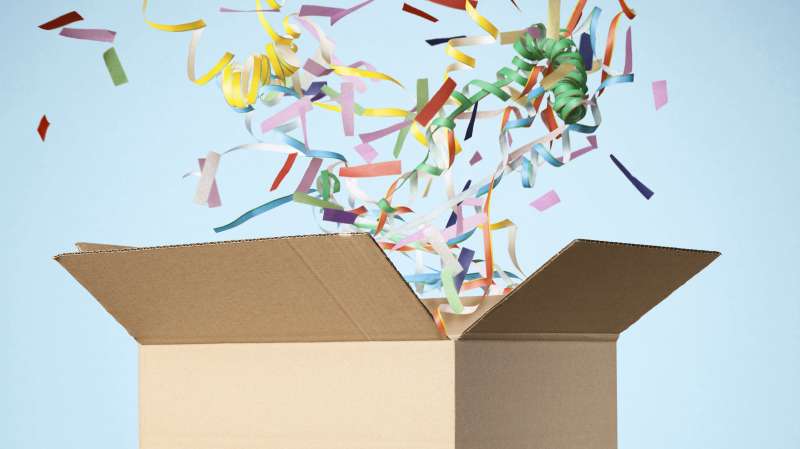 shipping box with confetti and styrofoam peanuts coming out of it