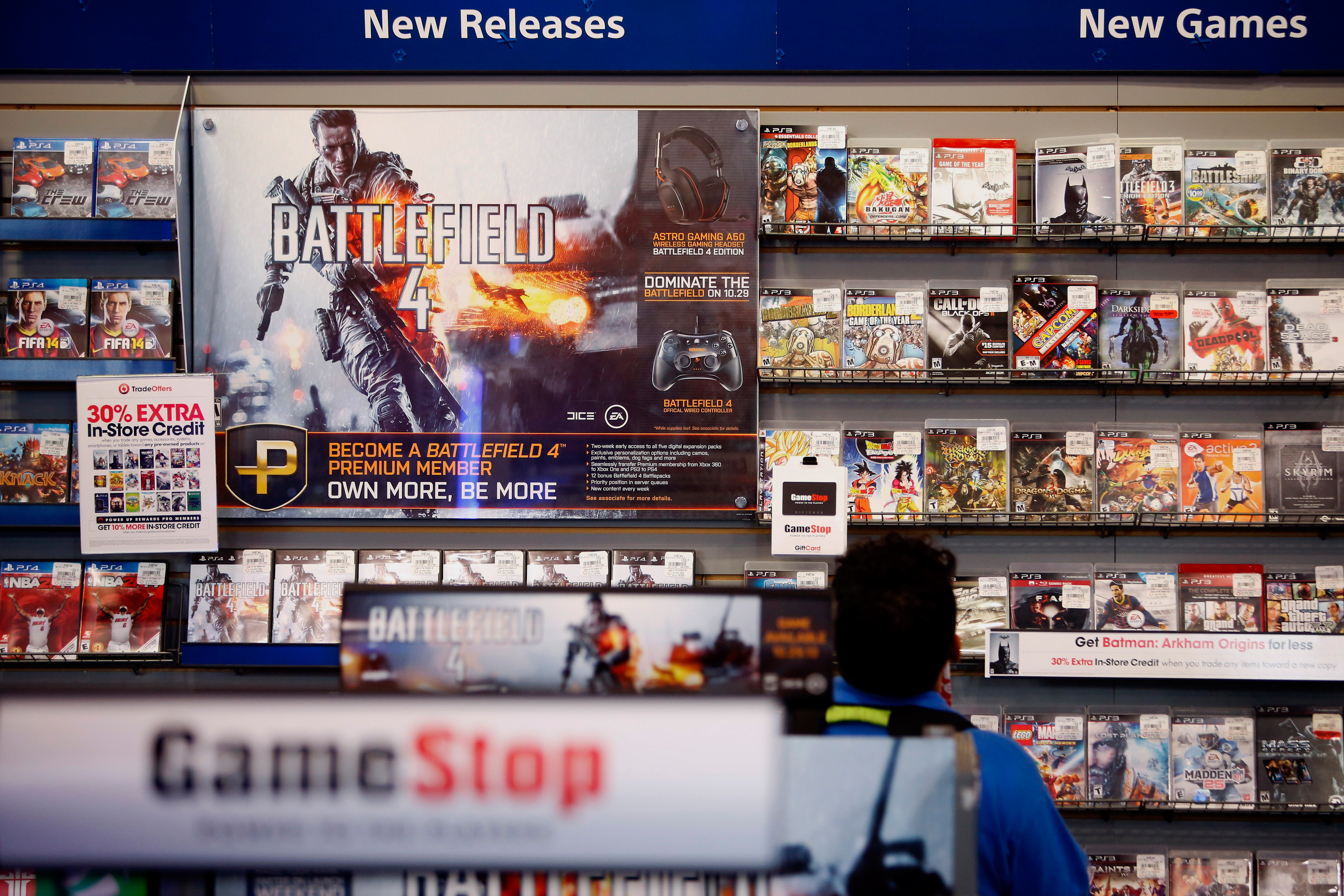 An Electronic Arts Inc. Battlefield 4 video game advertisement is displayed as a customer browses at a GameStop Corp. store in West Hollywood, California, U.S.