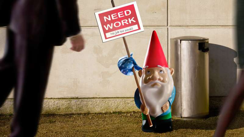 Garden gnome with  need work  sign