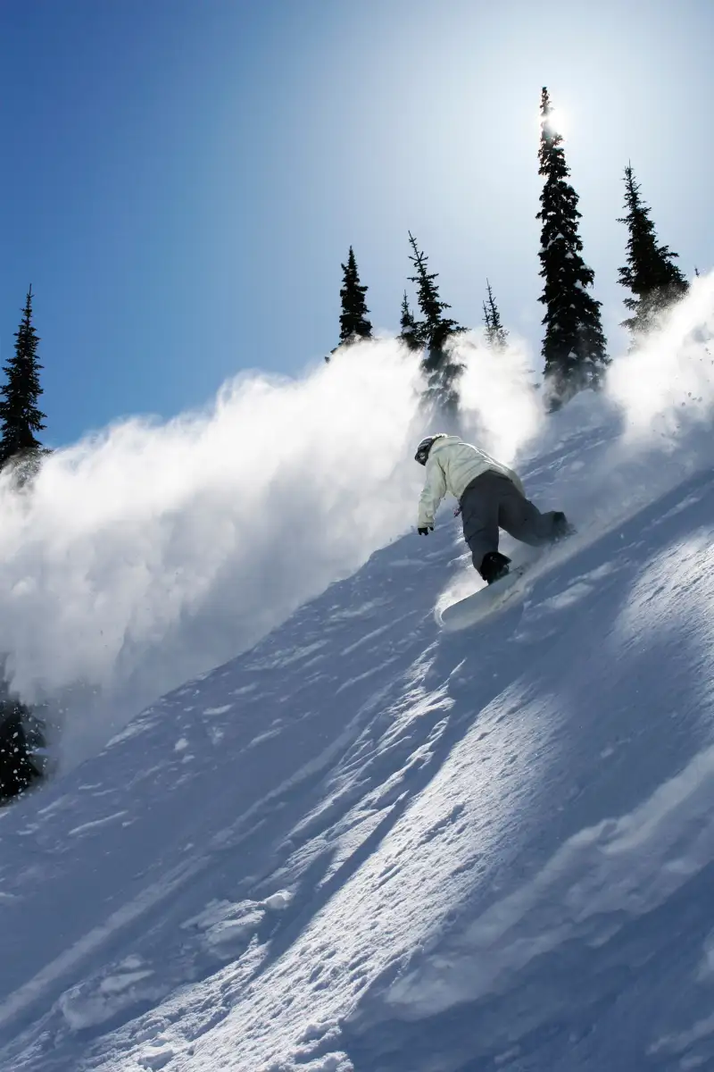 A male snowboarder ripping powder in Idaho.